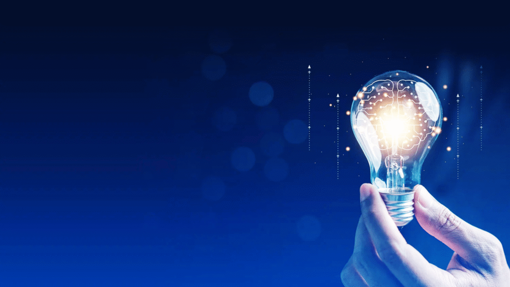Mão segurando lâmpada acesa com cérebro digital e circuitos internos, simbolizando inovação, ideias, inteligência artificial e competitividade empresarial.