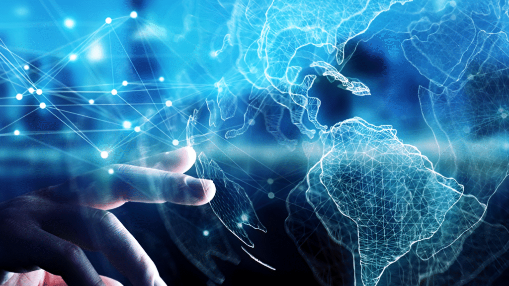 Mão humana tocando um mapa-múndi holográfico azul com conexões de rede, representando inovação global, transformação digital e estratégia de competitividade.